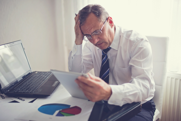 Business owner reviewing insurance documents, highlighting common business insurance mistakes in Malaysia related to coverage.